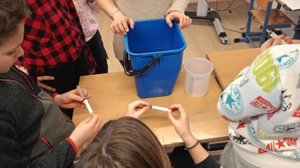Maestra che spiega le misure di capacità ad un gruppo di alunni